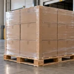 Palette de cartons alignés et maintenus par un film transparent sur un quai